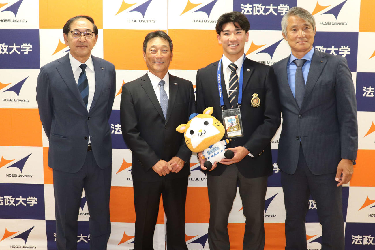 左から進藤チーム統括本部長補佐、大島法大監督、DeNA・2位指名のあいさつを受けた篠木、河野スカウト（撮影・保坂淑子）