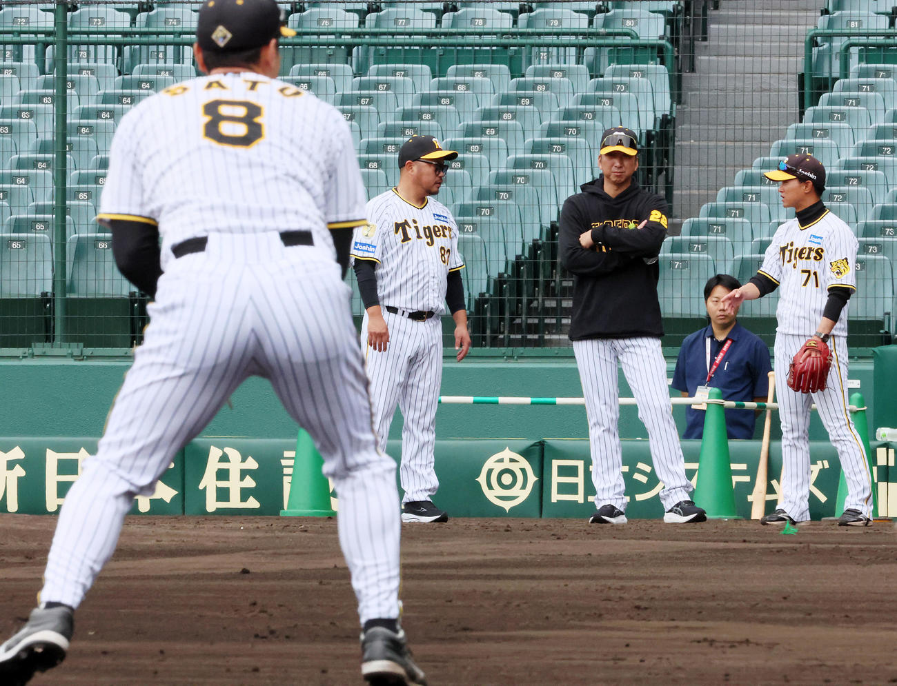 佐藤輝（左）の守備練習を見守る左から小谷野コーチ、藤川監督、上本コーチ（撮影・加藤哉）