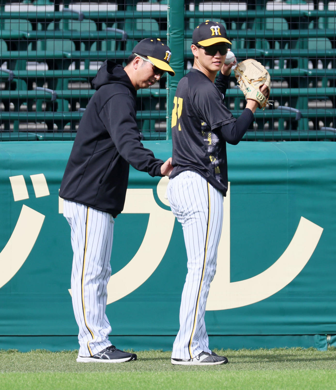 キャッチボールする及川（右）の腰に手を伸ばす藤川監督（撮影・加藤哉）
