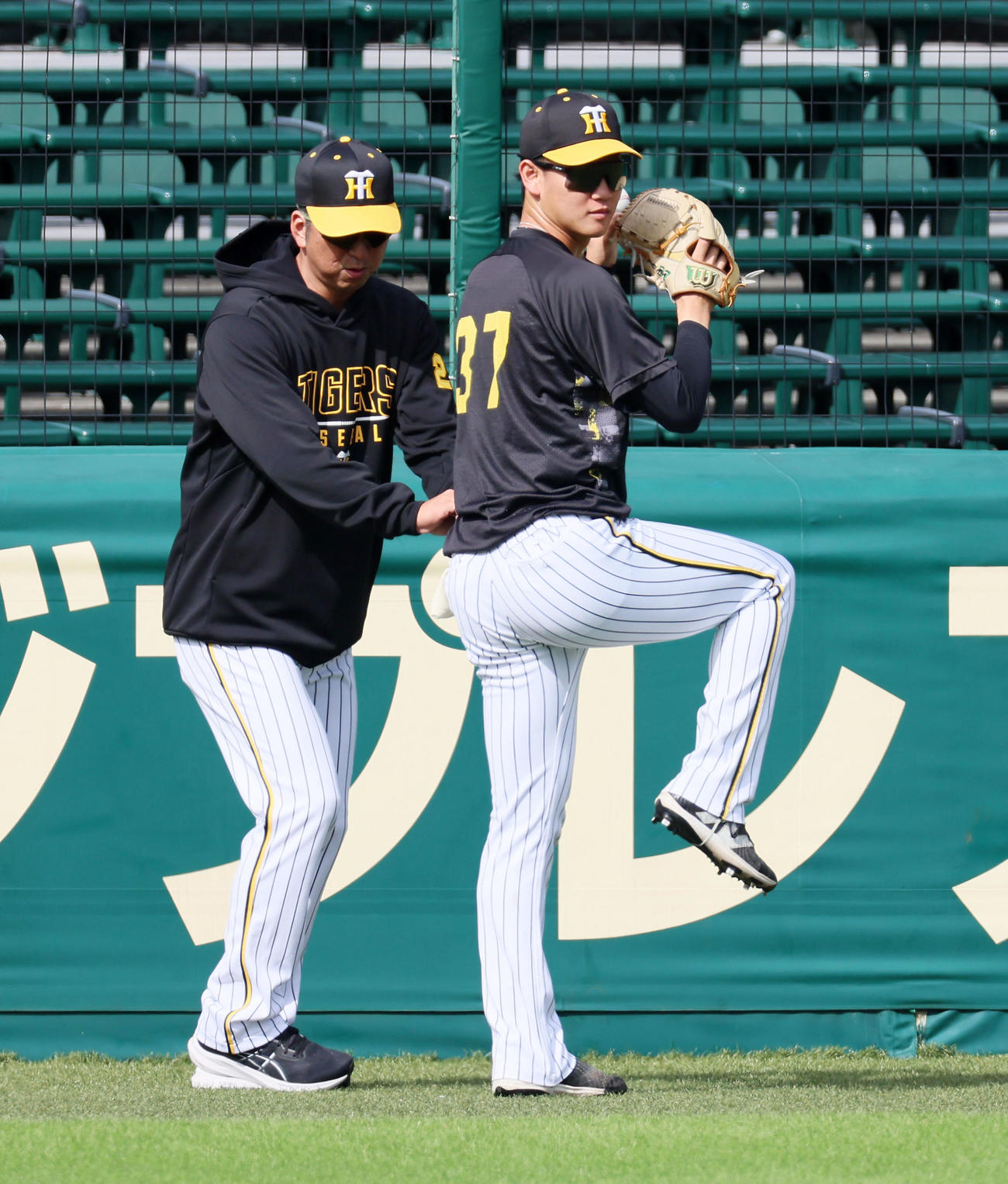 キャッチボールする及川（右）の腰に手を伸ばす藤川監督（撮影・加藤哉）