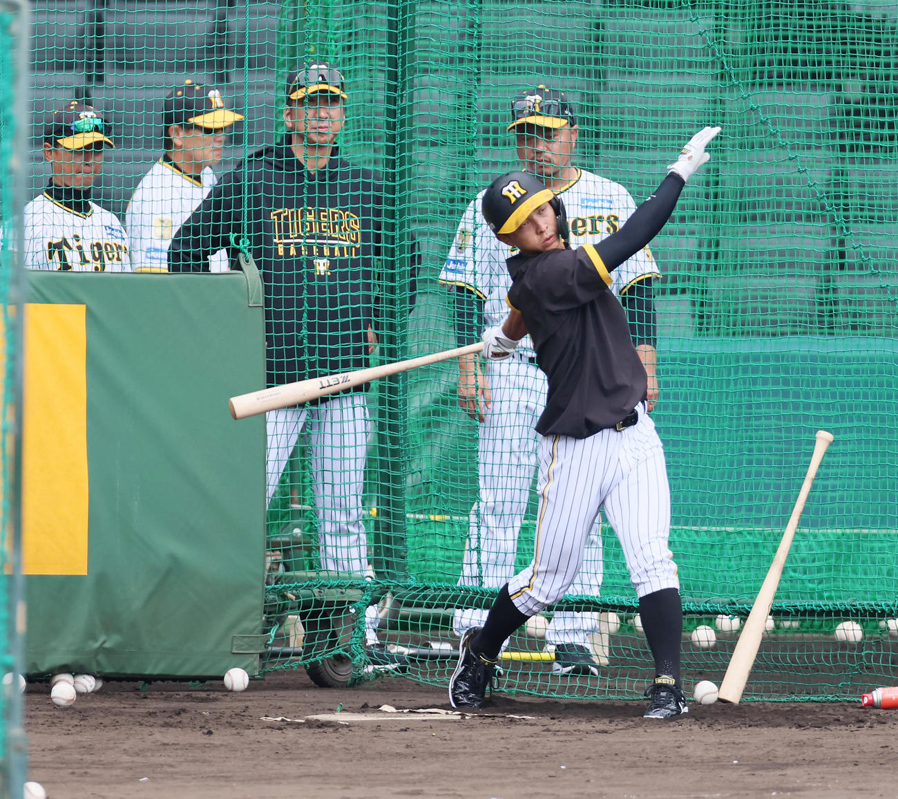 打撃練習する熊谷。後方は左から上本コーチ、藤川監督、小谷野チーフコーチ（撮影・加藤哉）