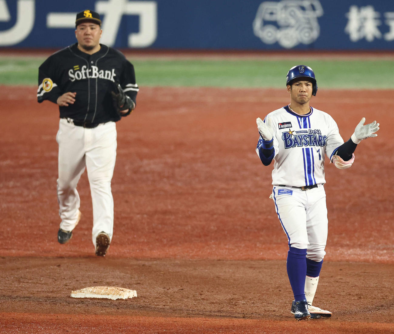 DeNA対ソフトバンク　5回裏DeNA1死二、三塁、2点適時二塁打を放ち手をたたく桑原。左は山川（撮影・河田真司）