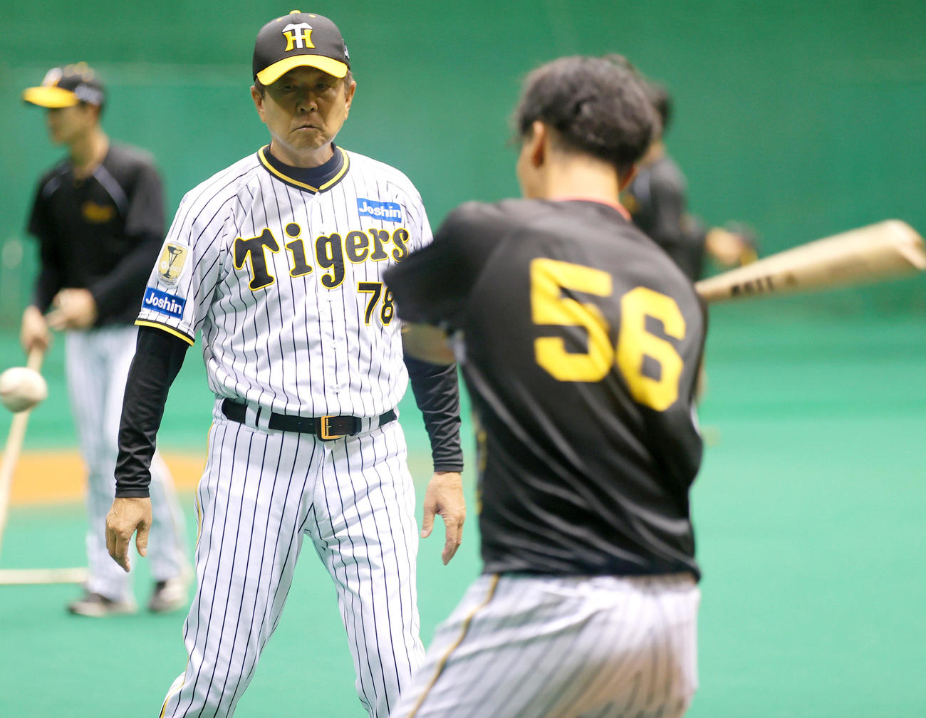 宮崎アイビースタジアムの室内で阪神平田2軍監督は百■（■は崎の大が立の下の横棒なし）（手前）の打撃を見る（撮影・上山淳一）