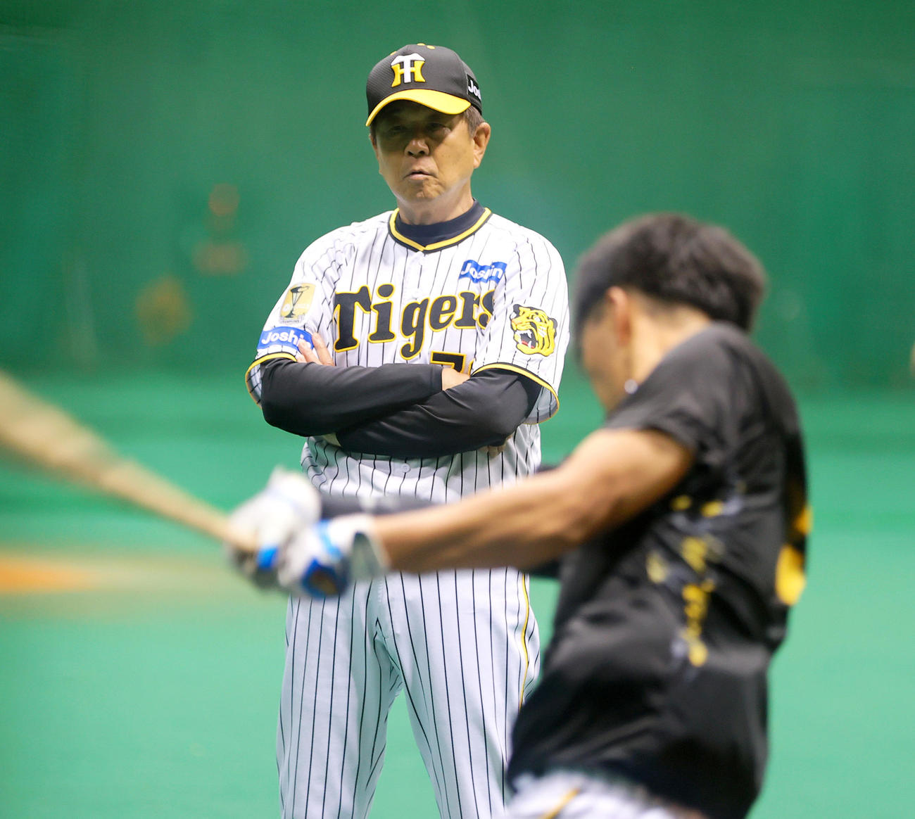 宮崎アイビースタジアムの室内で阪神平田2軍監督は百■（■は崎の大が立の下の横棒なし）（手前）の打撃を見る（撮影・上山淳一）