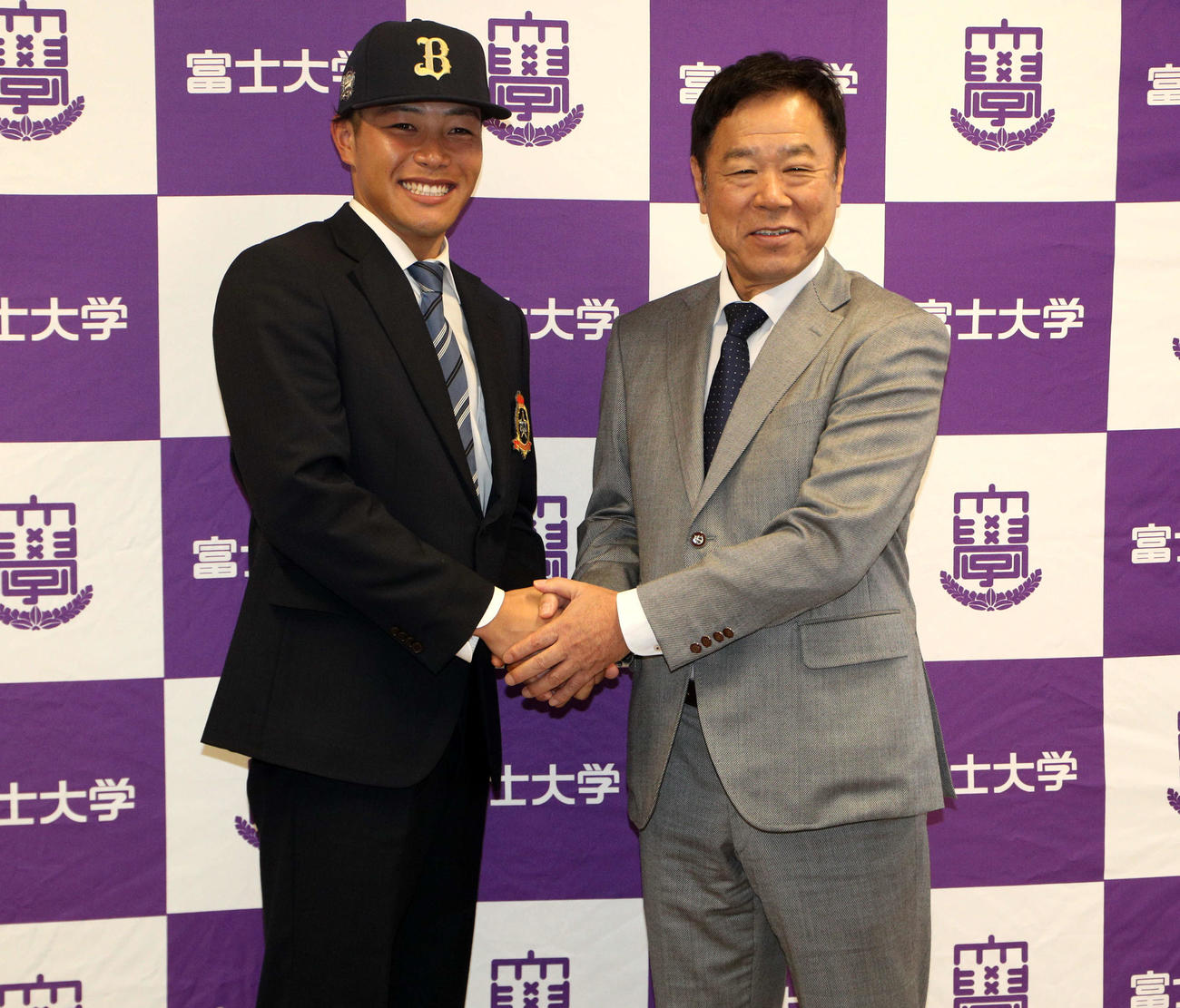 笑顔で握手をかわす富士大・麦谷（左）とオリックス福良GM（撮影・木村有優）