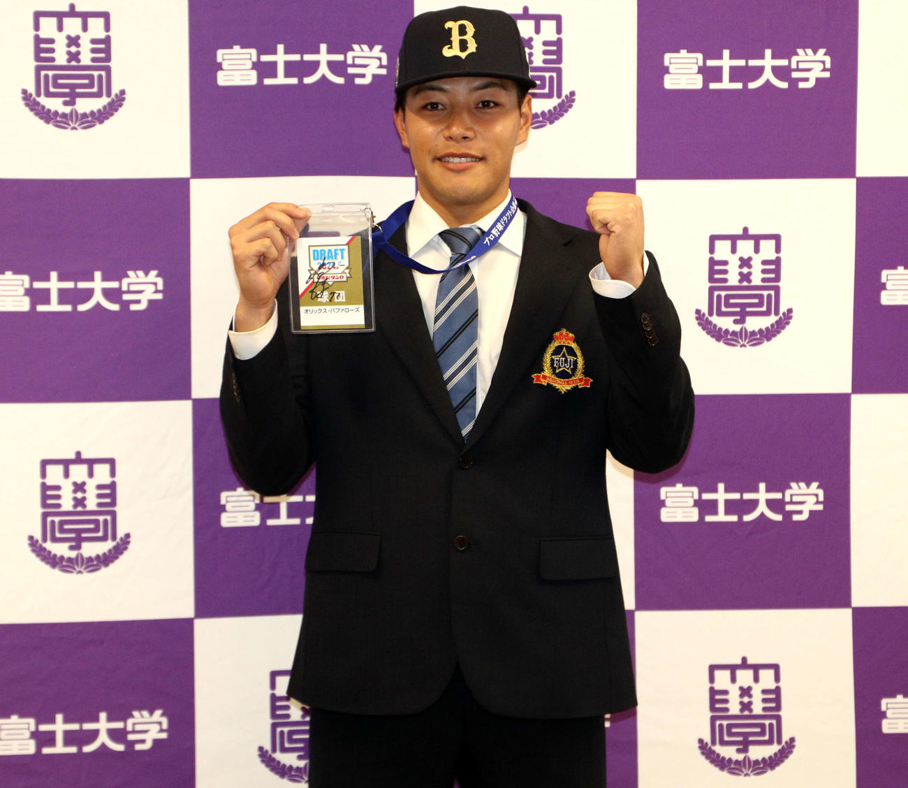 ドラフト会議での関係者パスを手にガッツポーズをする富士大・麦谷（撮影・木村有優）
