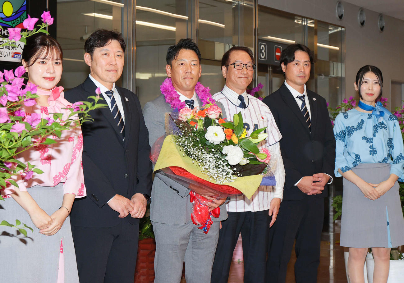 侍ジャパン井端監督（左から3人目）らは宮崎ブーゲンビリア空港に到着し歓迎を受ける。左から2人目は村田バッテリーコーチ、同5人目は亀井外野守備・走塁コーチ（撮影・上山淳一）