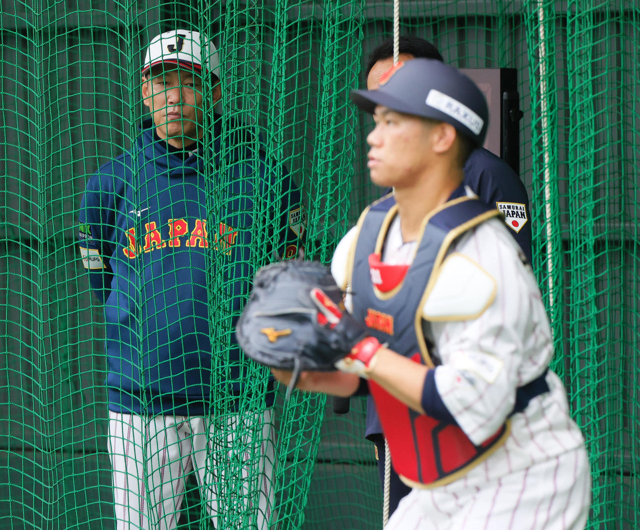 ブルペンで侍ジャパン井端監督は楽天鈴木翔の球を受ける広島坂倉（手前）を見つめる（撮影・上山淳一）