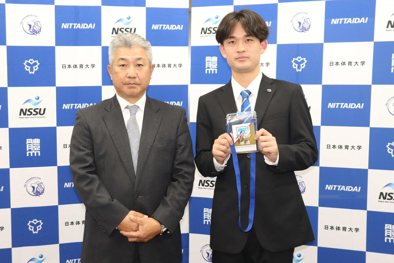 オリックス・2位指名のあいさつを受け、（写真左）日体大・古城隆利監督に報告する寺西（撮影・保坂淑子）