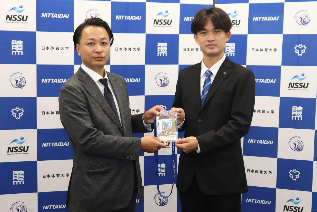 オリックス・2位指名のあいさつを受け、担当の小林敦スカウトからドラフト会議のパスをプレゼントされ笑顔を見せる寺西（撮影・保坂淑子）