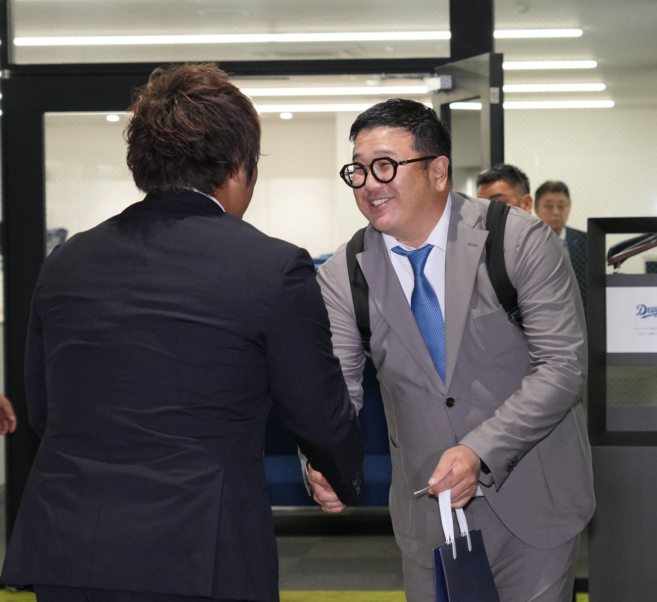 来季の中日投手コーチ就任が決まり同じく外野守備コーチ就任する平田と握手を交わす小山（右）（撮影・森本幸一）