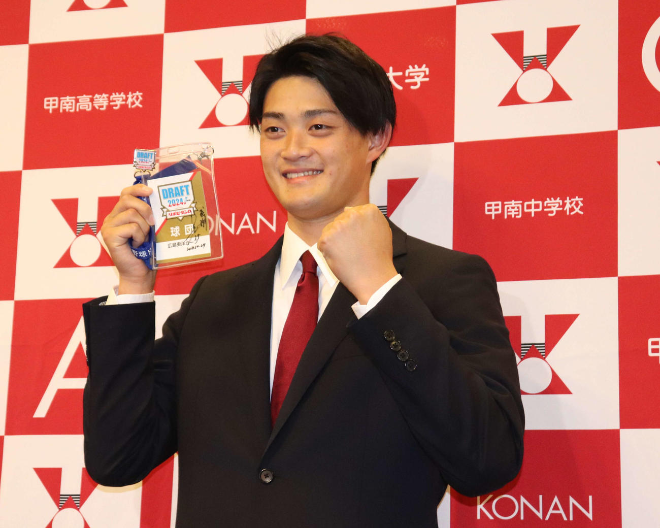 広島から3位指名を受け、新井貴浩監督の「感謝」と書かれたIDパスを持つ、甲南大・岡本駿（撮影・中島麗）
