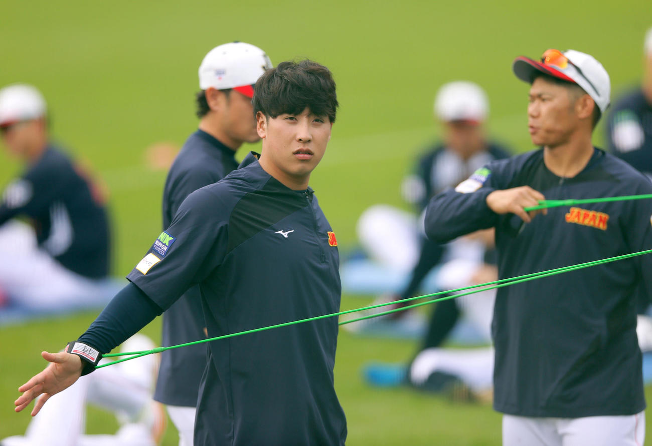 ゴムチューブでトレーニングする楽天藤平。右は広島坂倉（撮影・上山淳一）