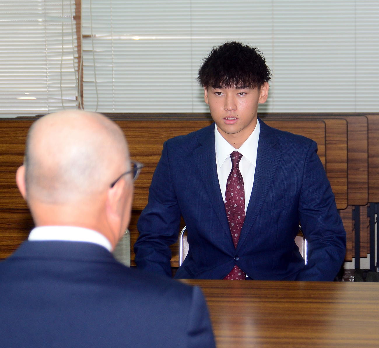 真剣な表情で話を聞く、くふうハヤテ・早川