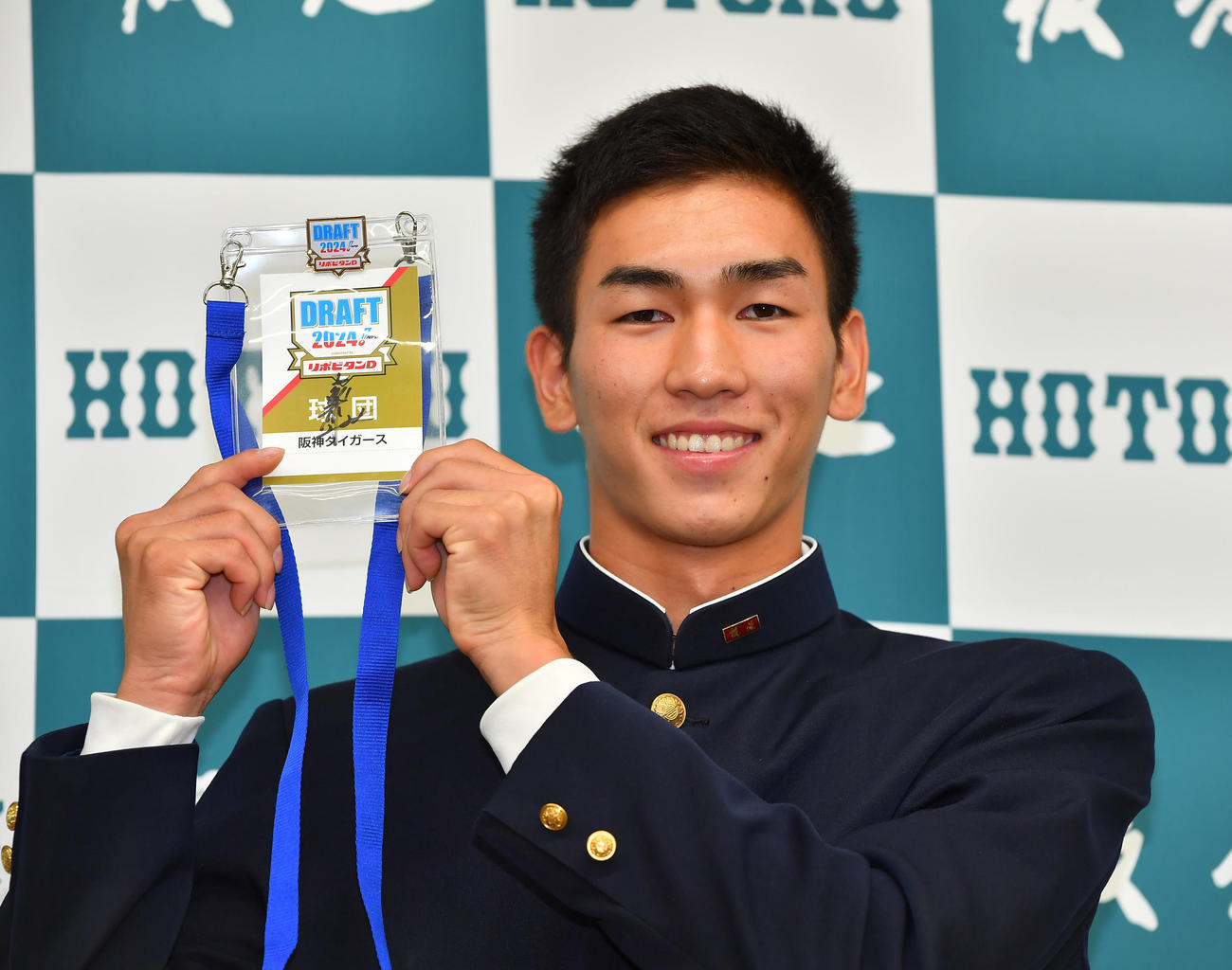 阪神からの指名あいさつを受け、藤川球児監督サイン入りのドラフト会議パスを手に笑顔を見せる報徳学園・今朝丸裕喜（撮影・清水貴仁）