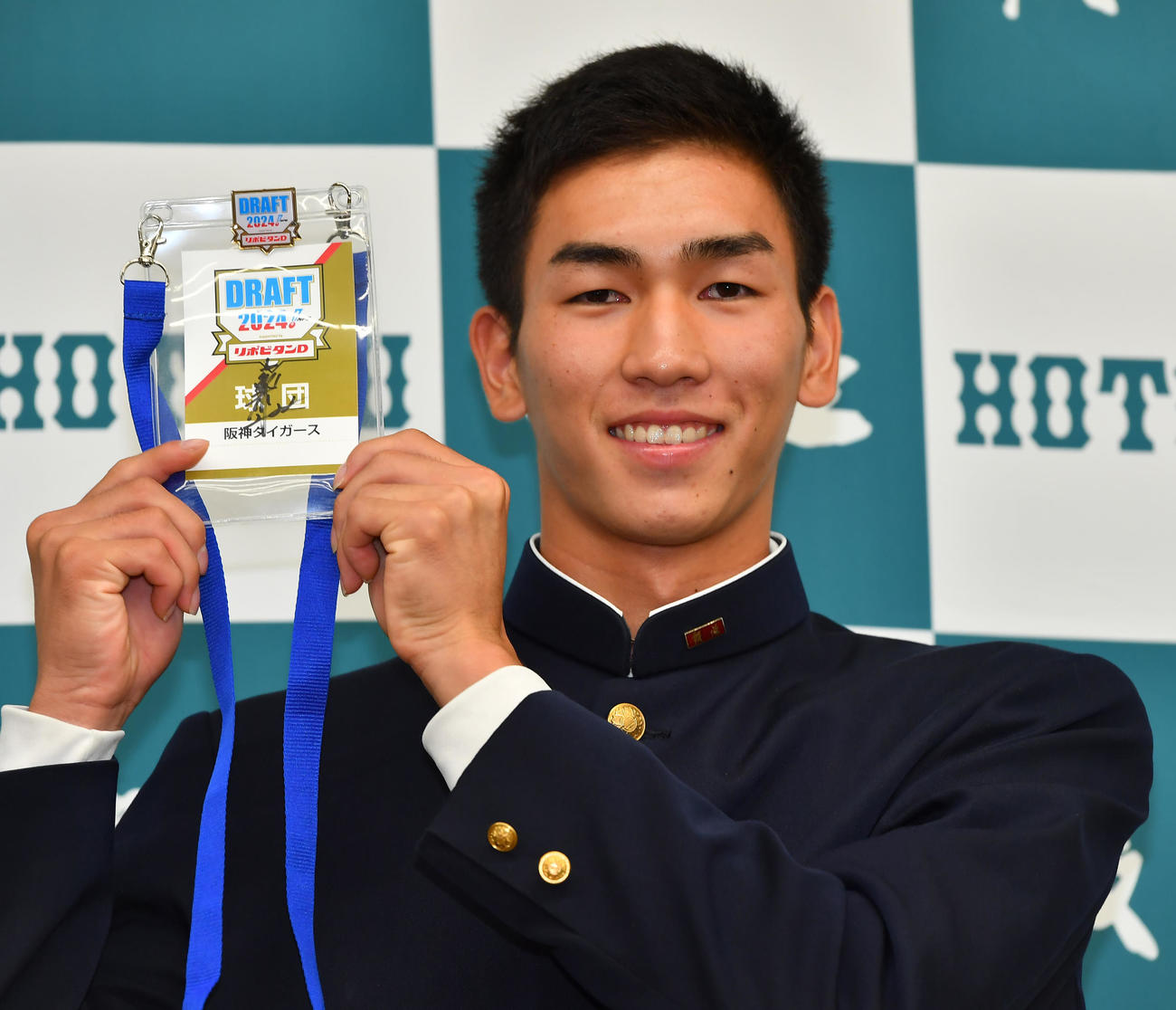 阪神からの指名あいさつを受け、藤川球児監督サイン入りのドラフト会議パスを手に笑顔を見せる報徳学園・今朝丸裕喜（撮影・清水貴仁）