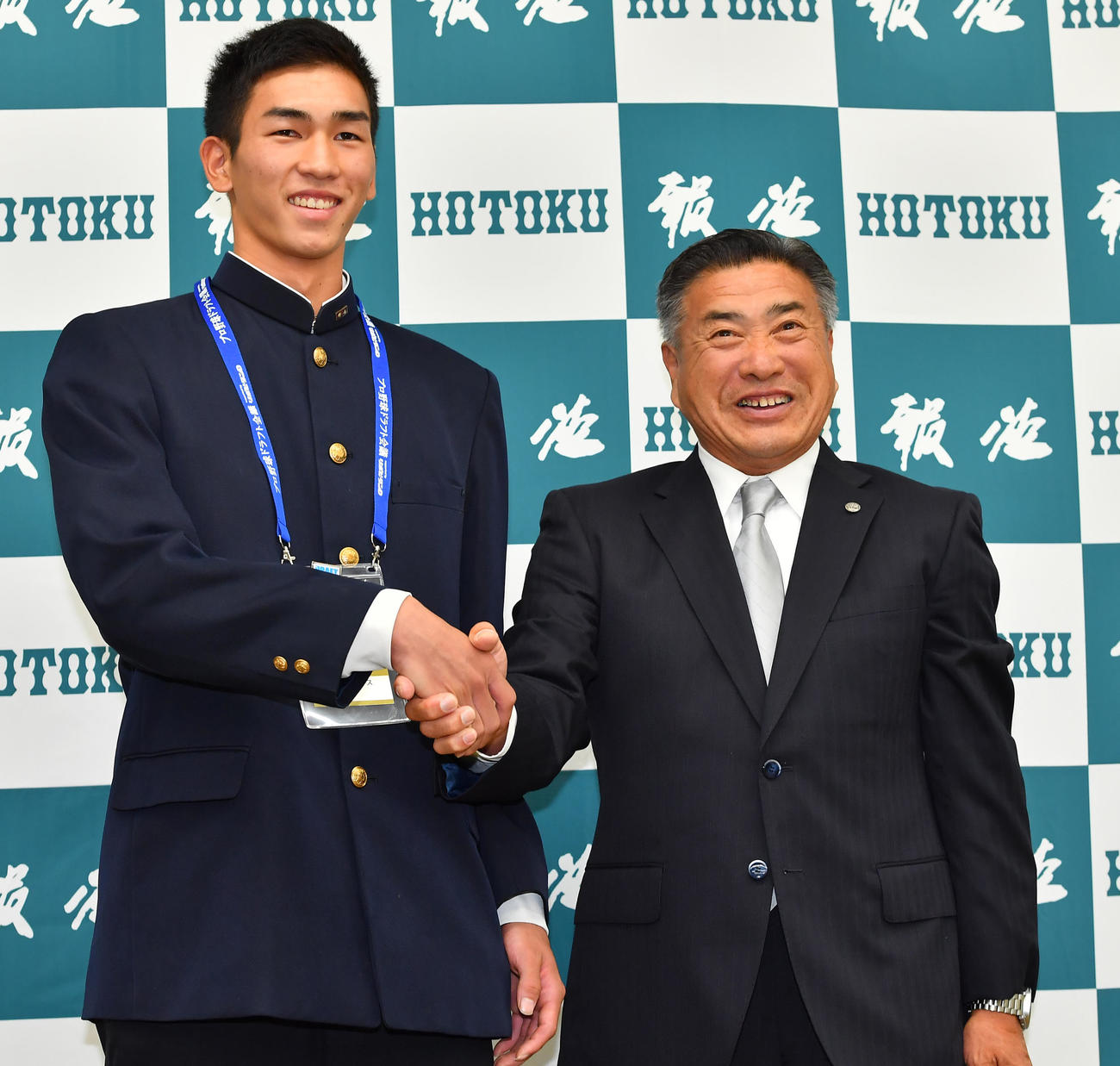 指名あいさつで阪神熊野スカウト（右）と握手を交わす報徳学園・今朝丸（撮影・清水貴仁）