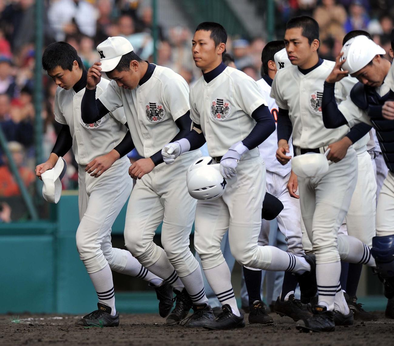 2010年4月2日、第82回選抜高校野球選手権大会・決勝　興南対日大三　優勝した興南ナインとあいさつしベンチに引き揚げる日大三エース山崎福也（左）らナイン