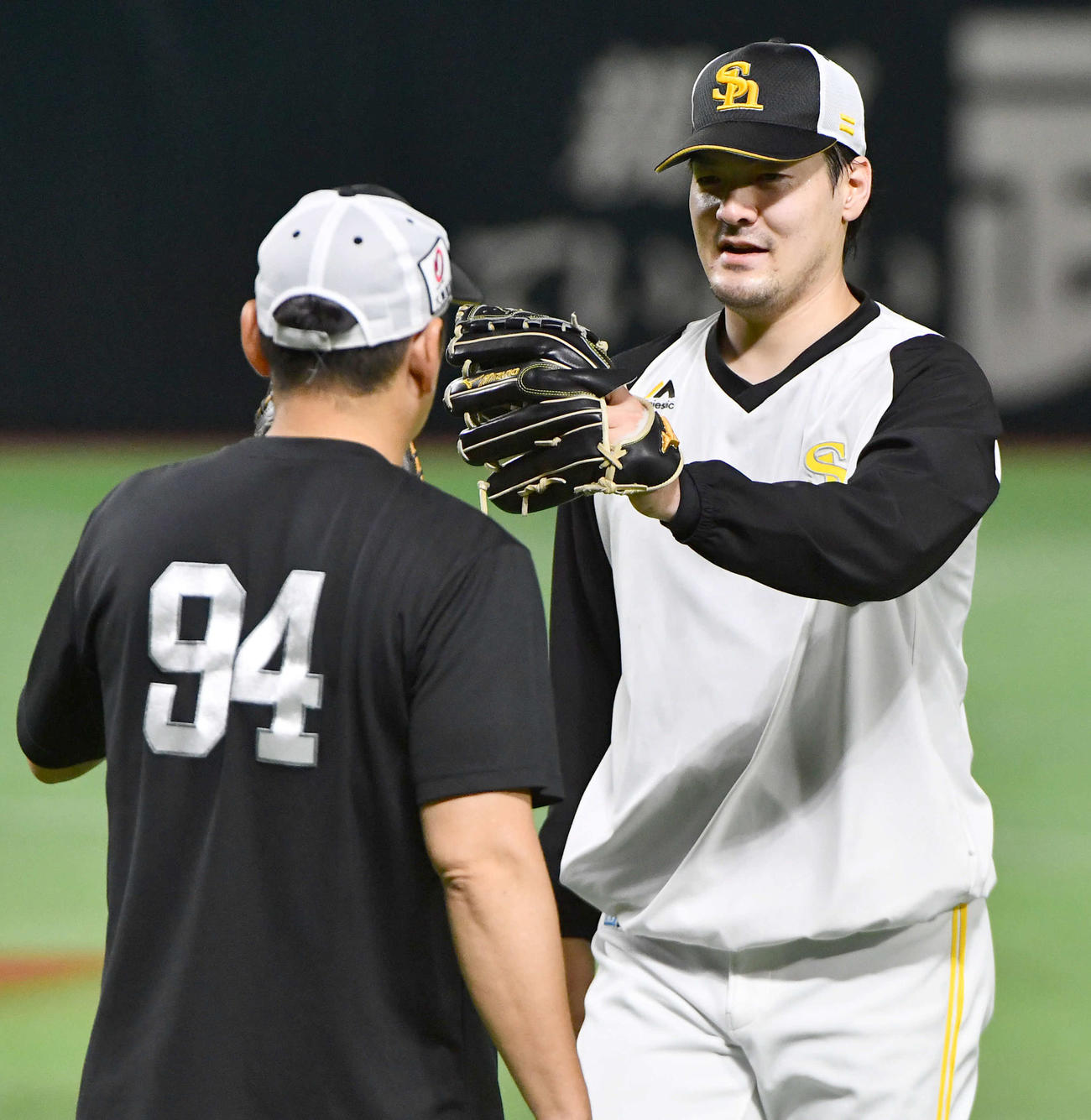 倉野コーチ（左）とのキャッチボールを終え、グラブタッチを交わす有原（撮影・岩下翔太）