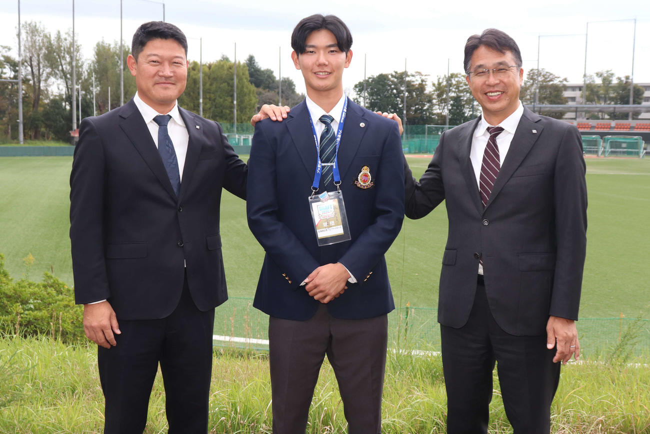 日ハム・3位指名のあいさつを受け笑顔で写真に写る（左から）山本スカウトグループ長、明大・浅利、大渕スカウト部長（撮影・保坂淑子）