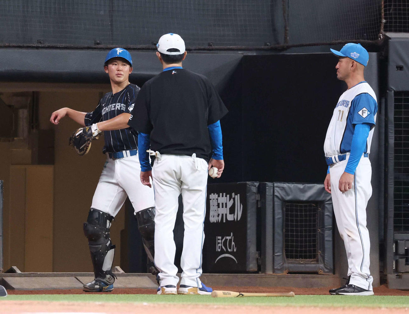 居残り練習で山田バッテリーコーチ（左から2人目）と的場2軍バッテリーコーチから指導を受ける日本ハム進藤（撮影・黒川智章）