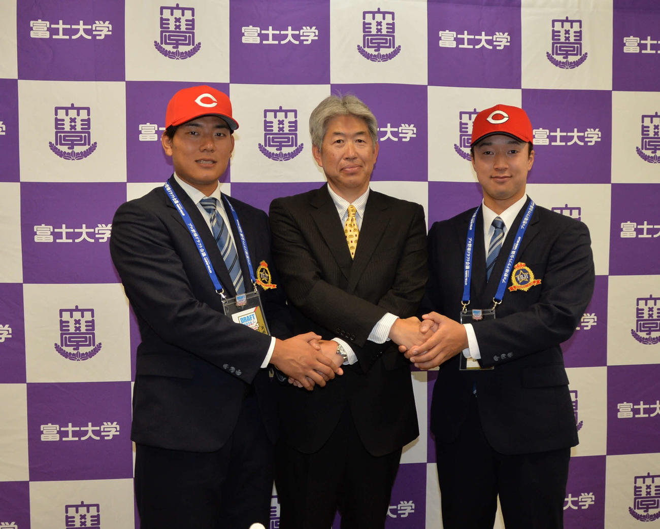 指名あいさつを受けた広島4位の渡辺（左）と同2位の佐藤（右）は近藤スカウト（中央）と固い握手で記念撮影（撮影・浜本神威）
