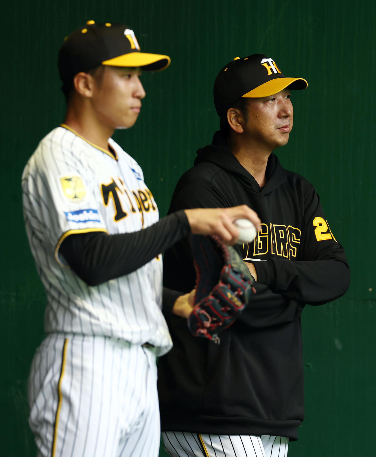 ブルペンで阪神茨木（左）の投球練習を見守る藤川監督（撮影・前田充）