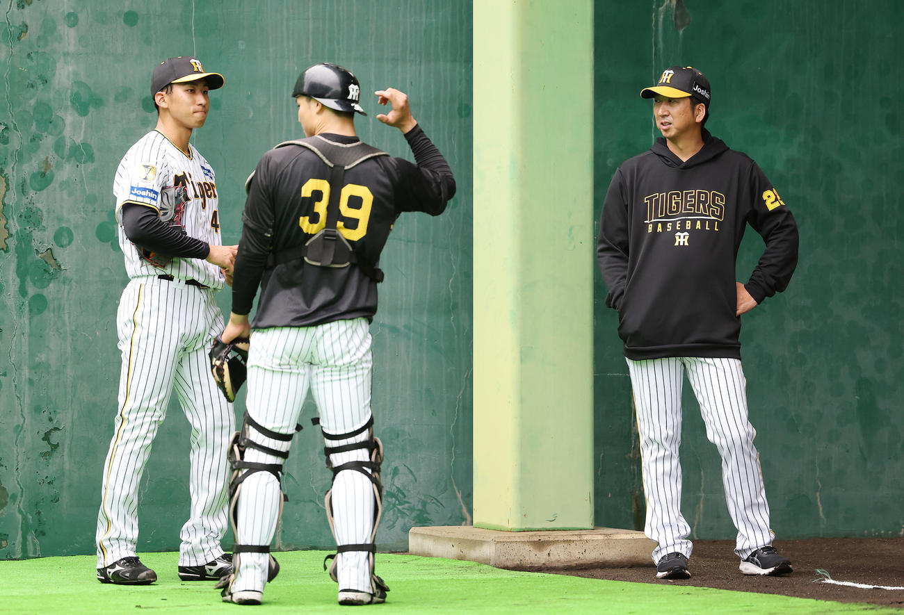 ブルペンで投球練習を終えた阪神茨木（左）、栄枝（中央）と言葉を交わす藤川監督（撮影・前田充）