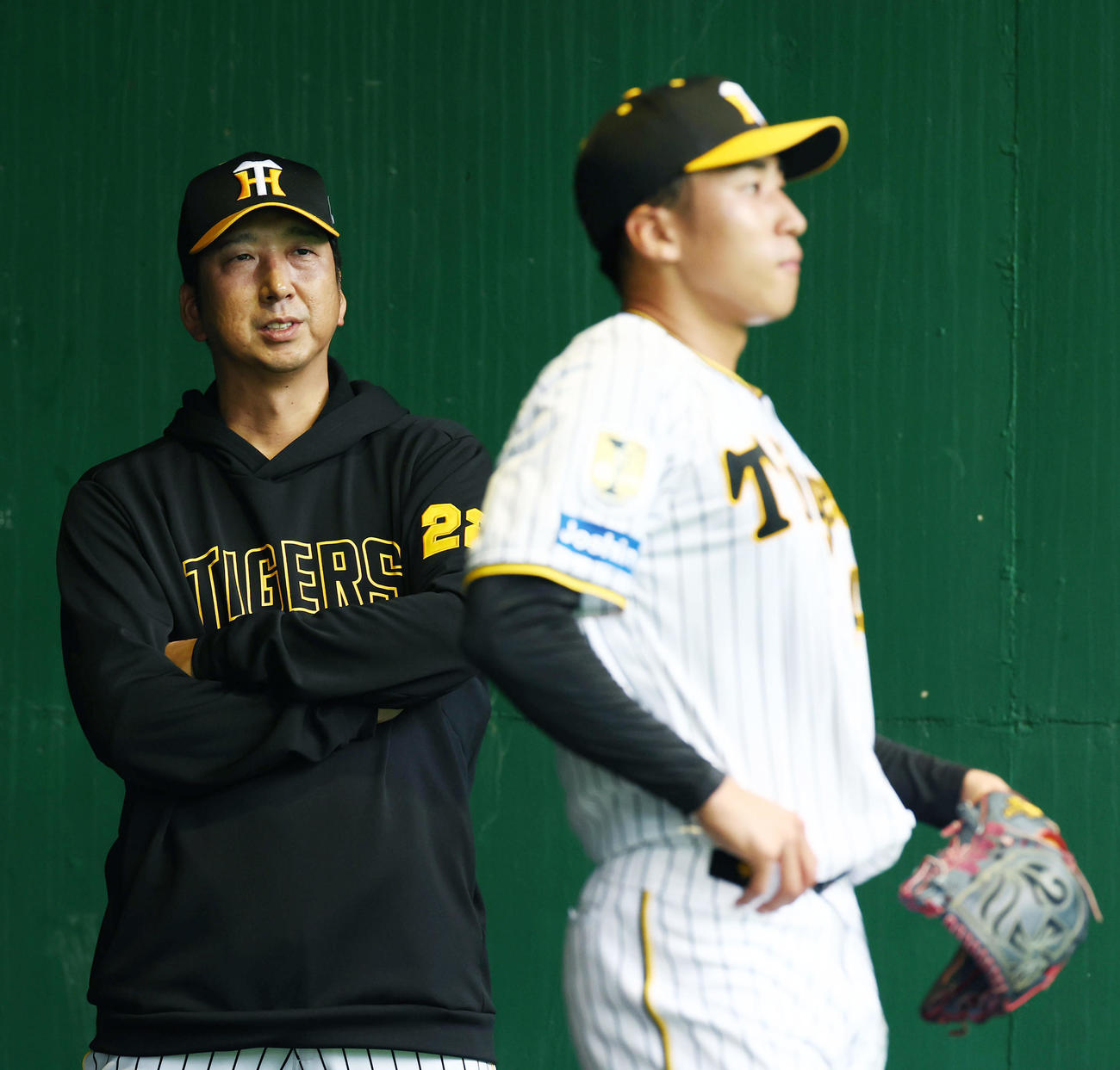 ブルペンで阪神茨木（右）の投球練習を見守る藤川監督（撮影・前田充）