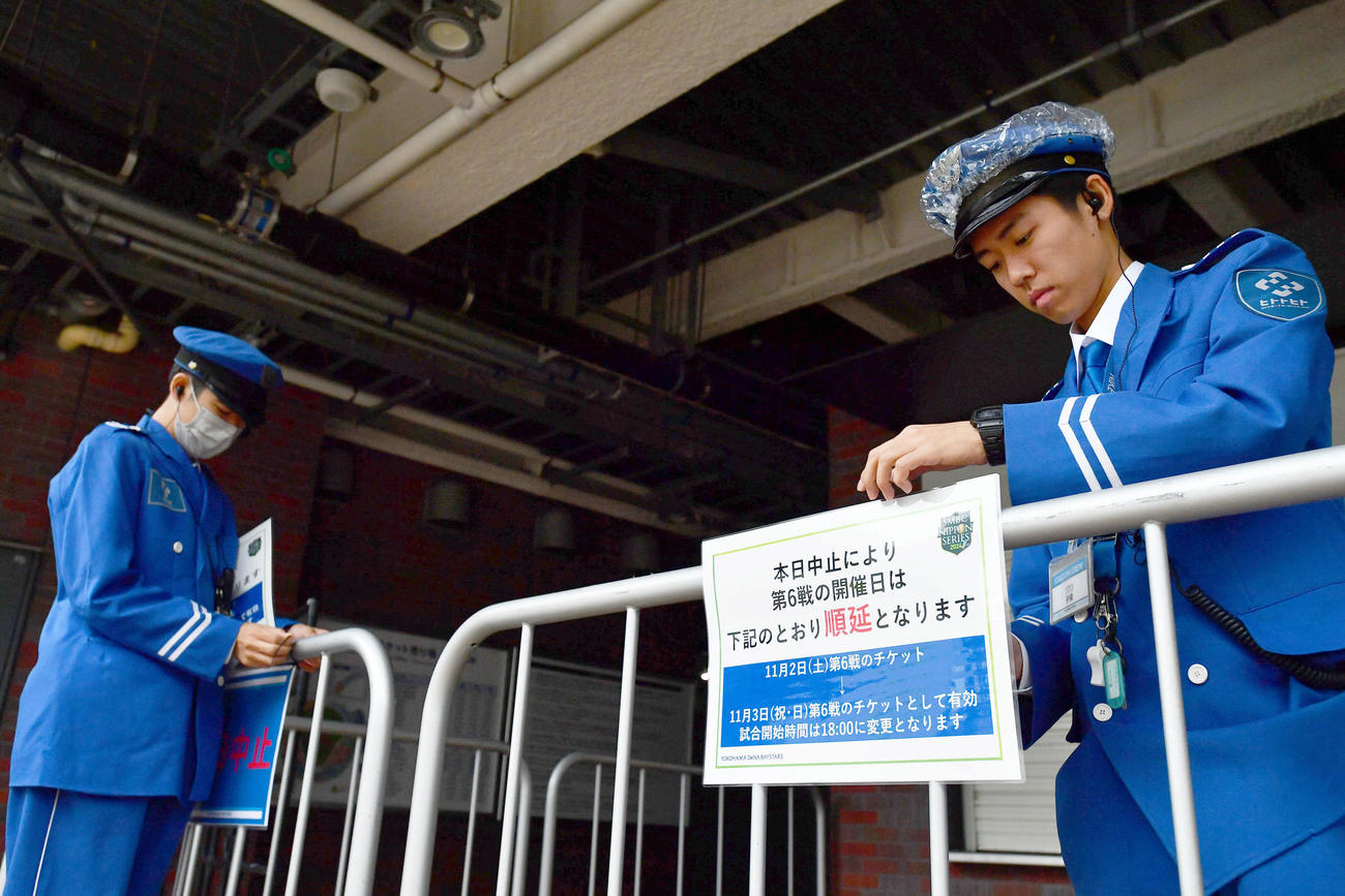 SMBC日本シリーズ2024第6戦が雨天順延となり、案内を貼る警備員たち（撮影・岩下翔太）