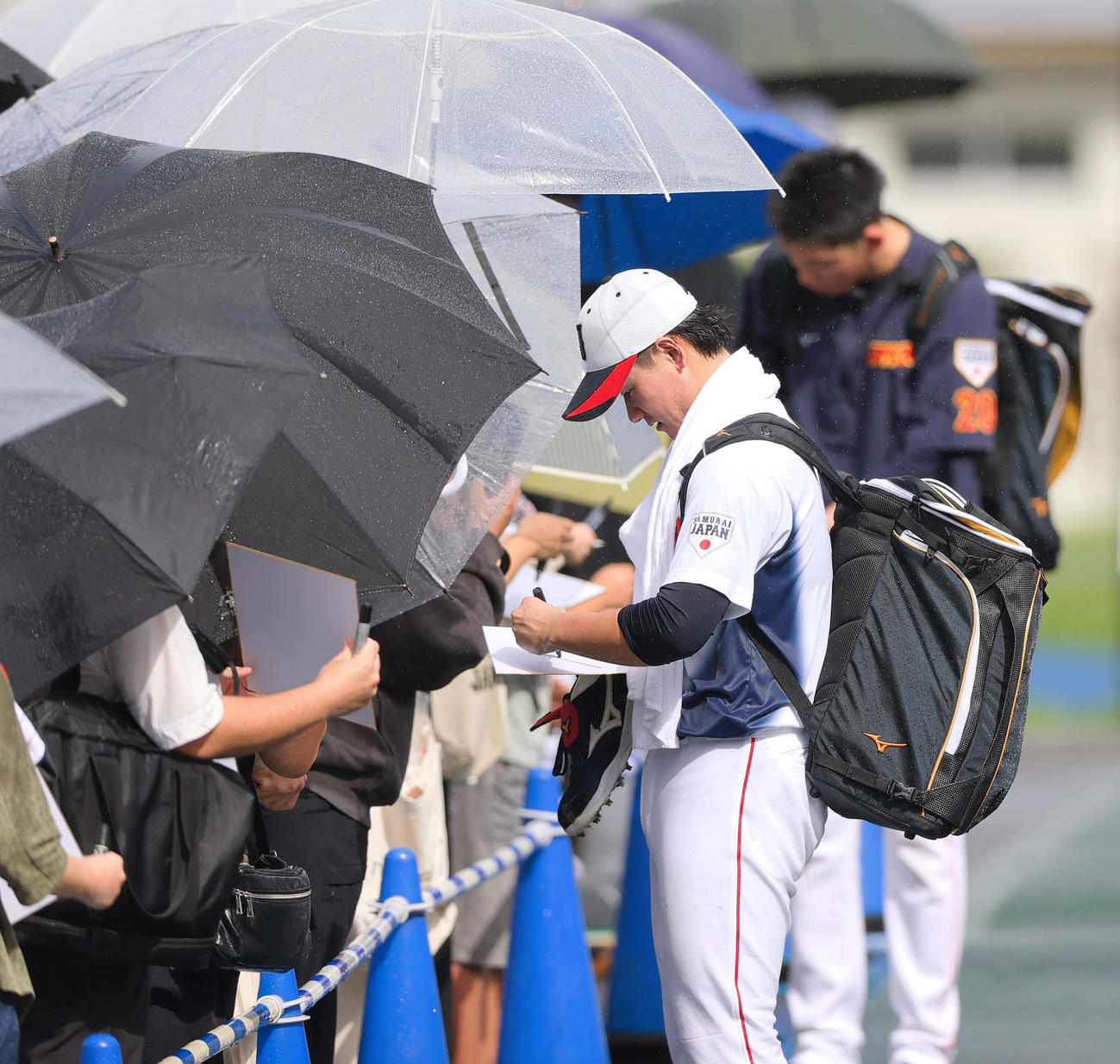 雨の中、ファンにサインする巨人井上（撮影・上山淳一）