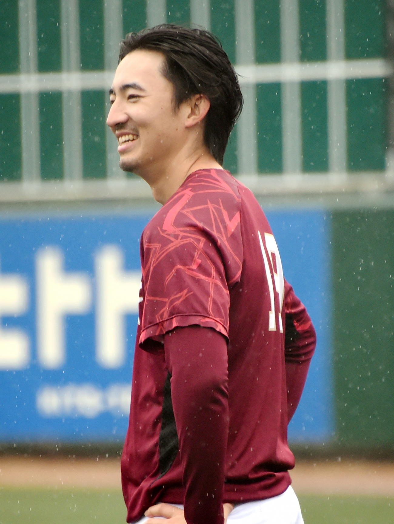 雨の降るグラウンドで笑顔で練習する楽天荘司（撮影・山田愛斗）