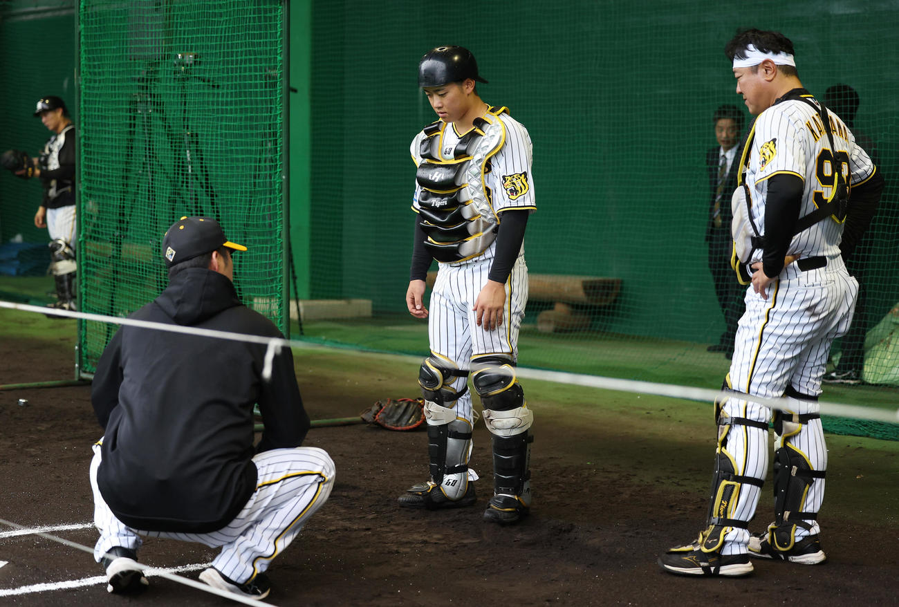 ブルペンで阪神藤川監督（左）の指導を受ける中川。右は片山ブルペンコーチ兼BC（撮影・前田充）