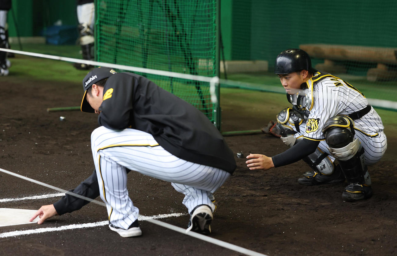 ブルペンで阪神藤川監督（左）の指導を受ける中川（撮影・前田充）