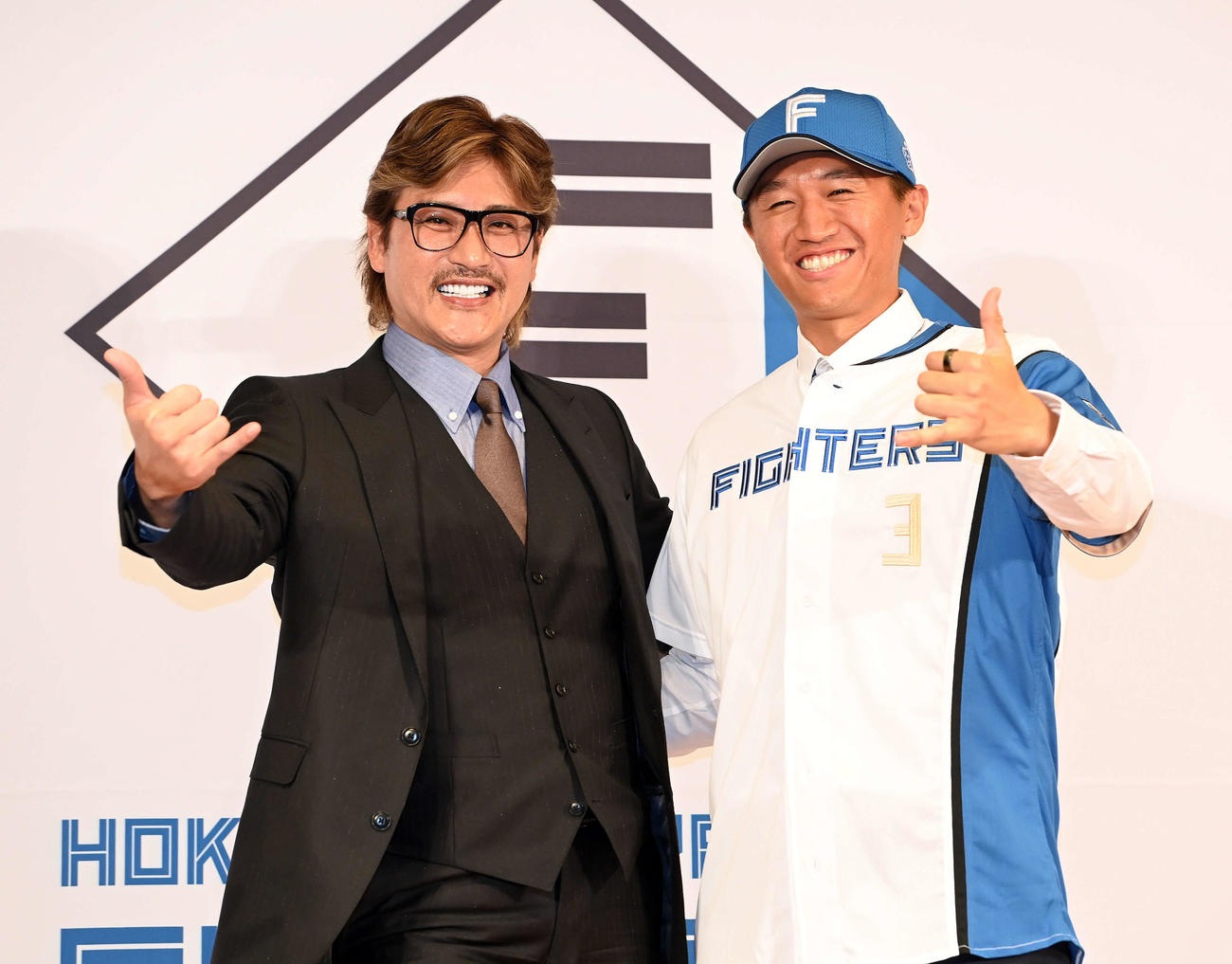 入団会見でポーズを決める新庄剛志監督（左）と日本ハムドラフト3位の加藤豪将（2022年11月撮影）