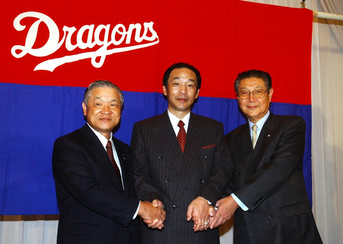 03年10月8日　就任会見を行った中日・落合博満新監督（中）は白井文吾オーナー（左）、西川順之助球団社長と握手を交わす