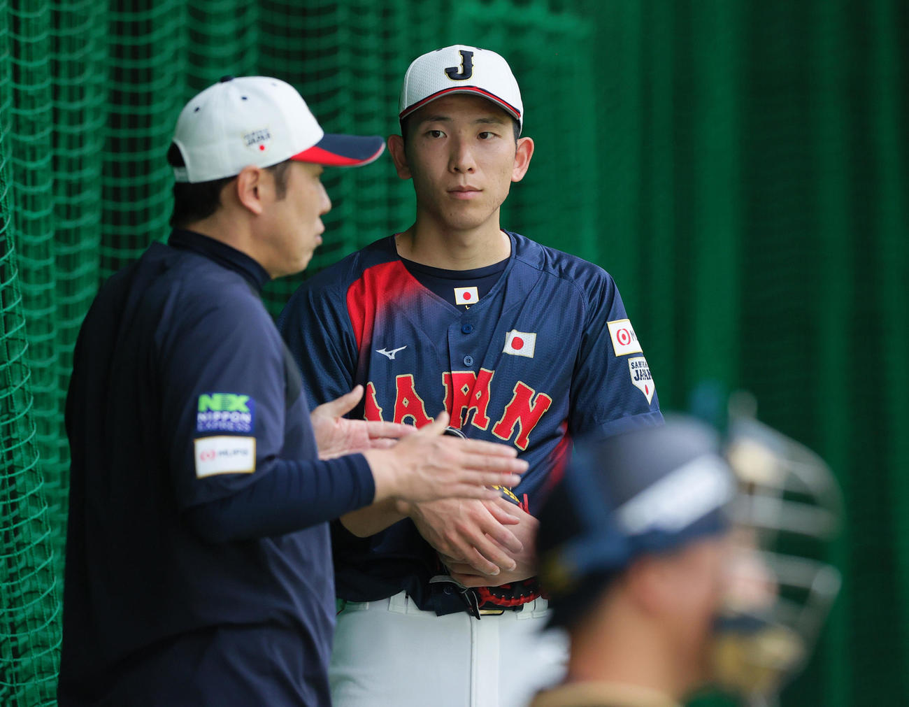 ブルペンで投球を終えた巨人戸郷は村田バッテリーコーチの話を聞く（撮影・上山淳一）
