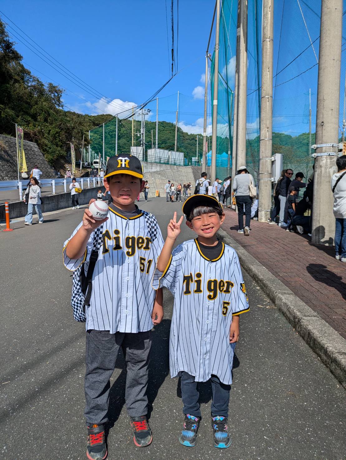 阪神前川右京の場外弾を拾った「現場」付近でポーズをとる福島愛翔くん（左）と愛悠くん＝2024年11月4日