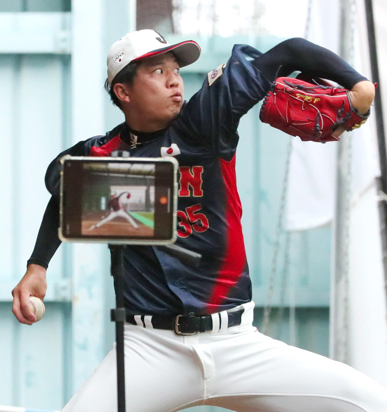 動画を録りながらブルペンで投げ込む阪神才木（撮影・上山淳一）