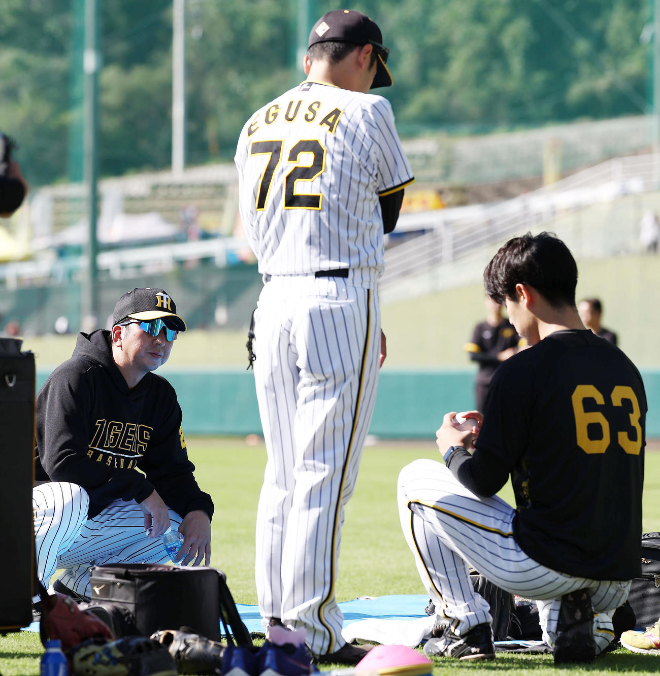 ブルペンに入り前、阪神石黒（右）を直接指導する藤川監督。中央は江草コーチ（撮影・前田充）