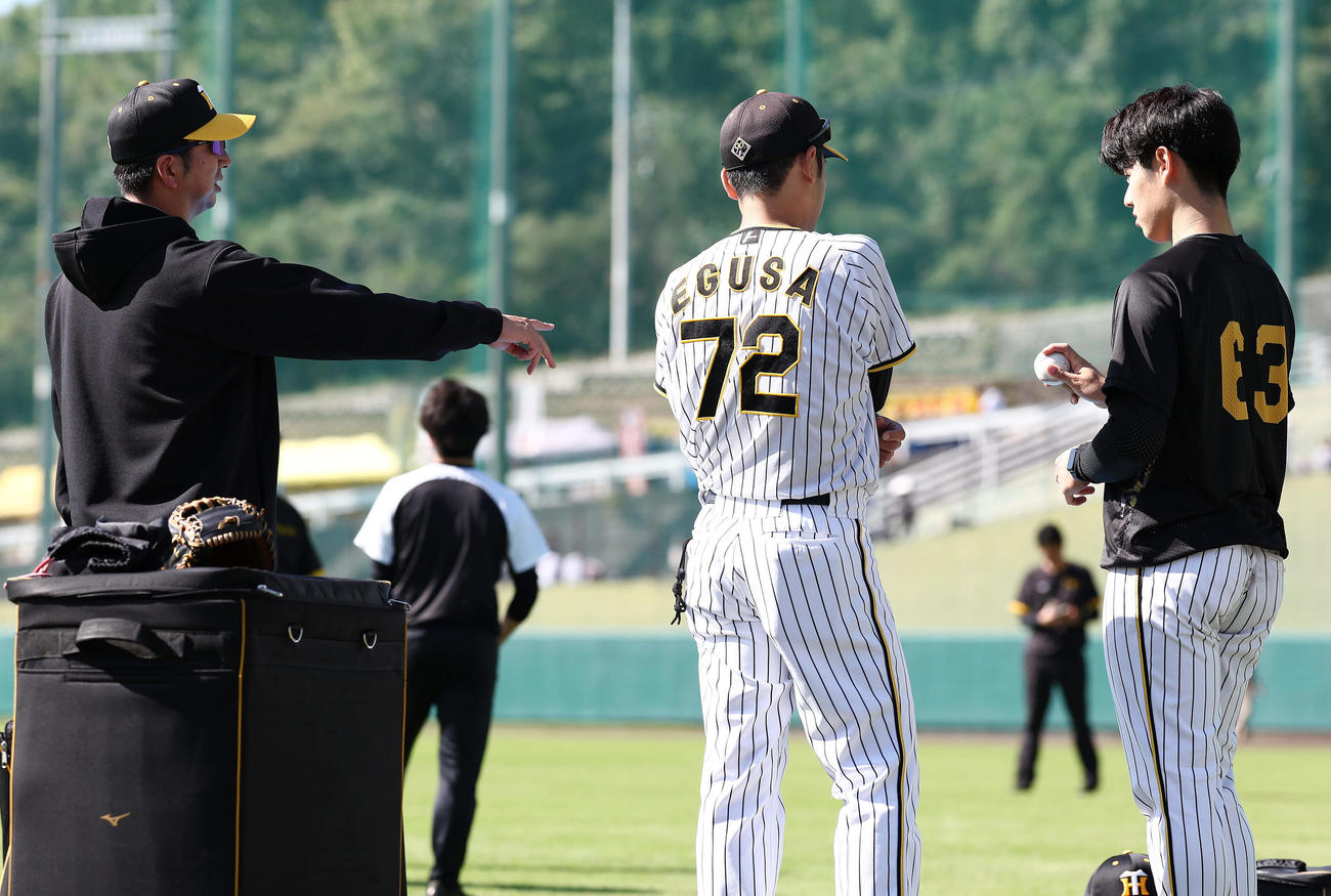 ブルペンに入り前、阪神石黒（右）を直接指導する藤川監督。中央は江草コーチ（撮影・前田充）