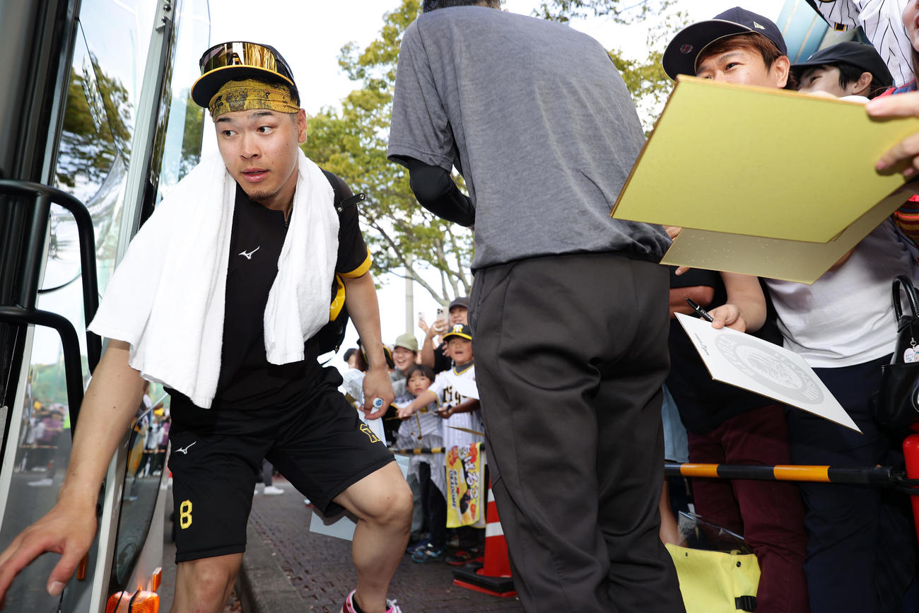 練習を終えバスに乗り込む阪神佐藤輝（左）（撮影・前田充）