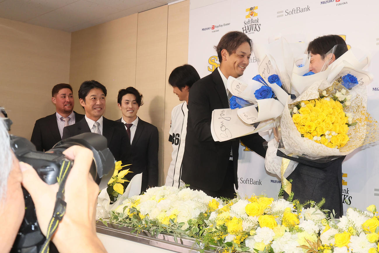 新垣渚氏（左）から花束を受け取る和田（撮影・鬼束羽瑠菜）