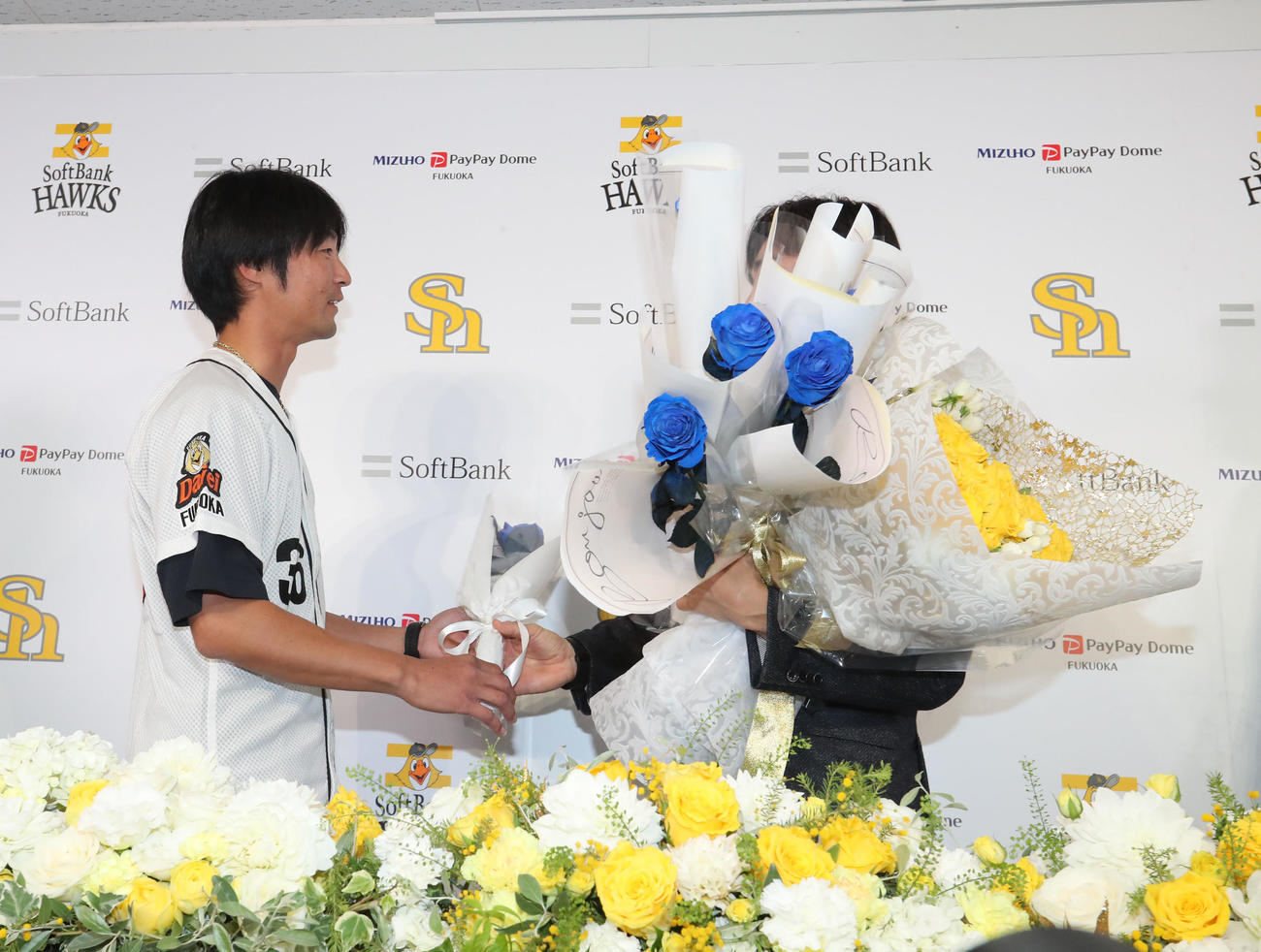 和田に花をプレゼントする明石コーチ（撮影・梅根麻紀）