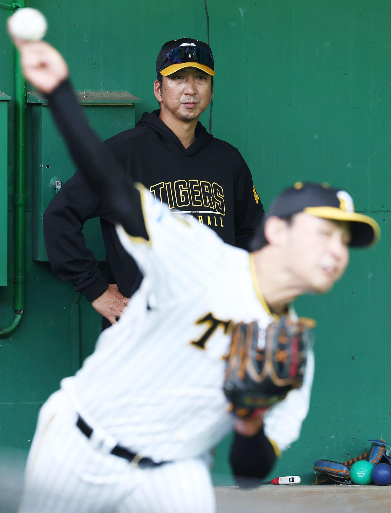 ブルペンで阪神佐藤蓮（手前）の投球練習を見守る藤川監督（撮影・前田充）