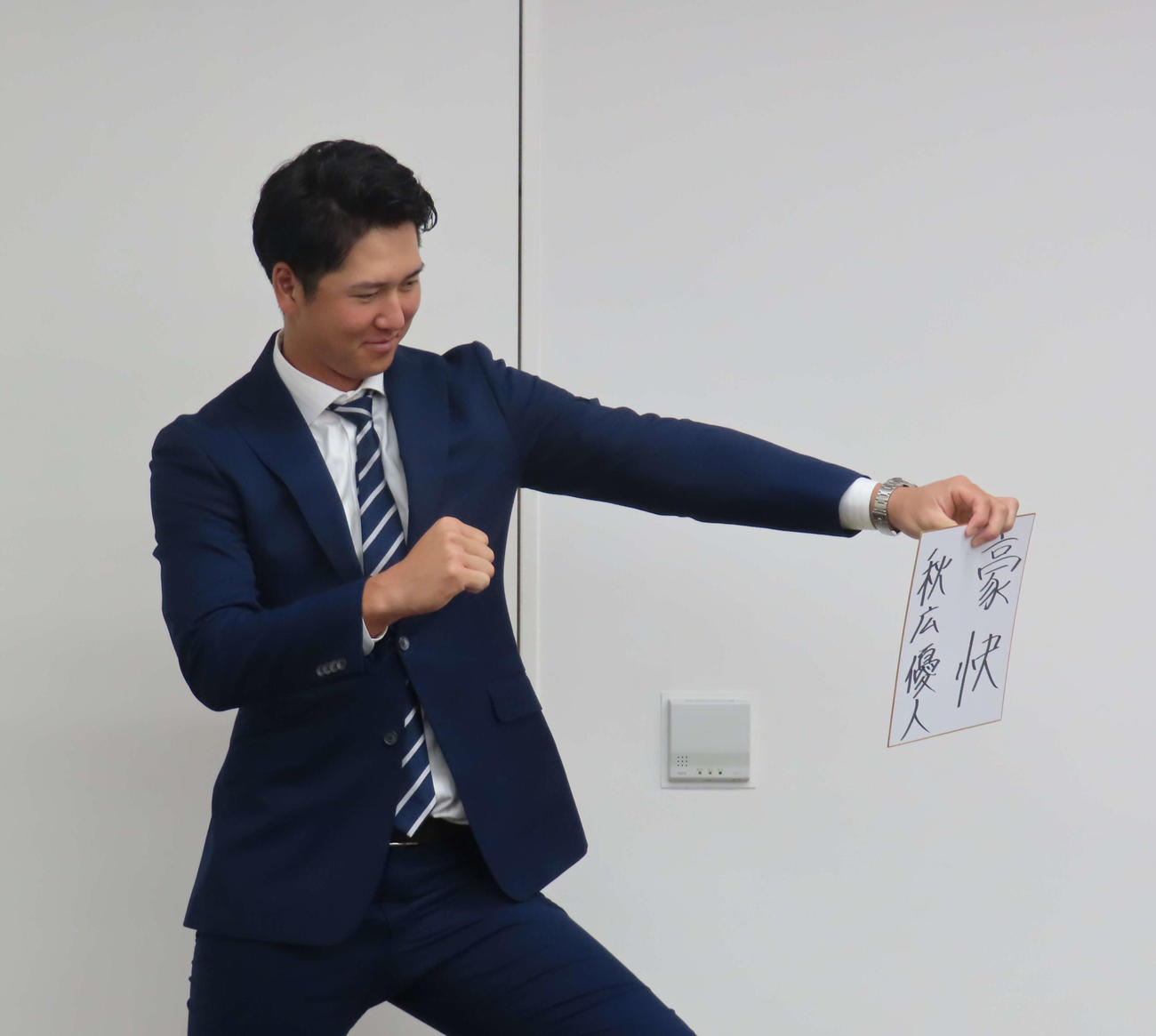 契約更改交渉を終え、色紙に「豪快」と書きポーズを決める巨人秋広（撮影・水谷京裕）