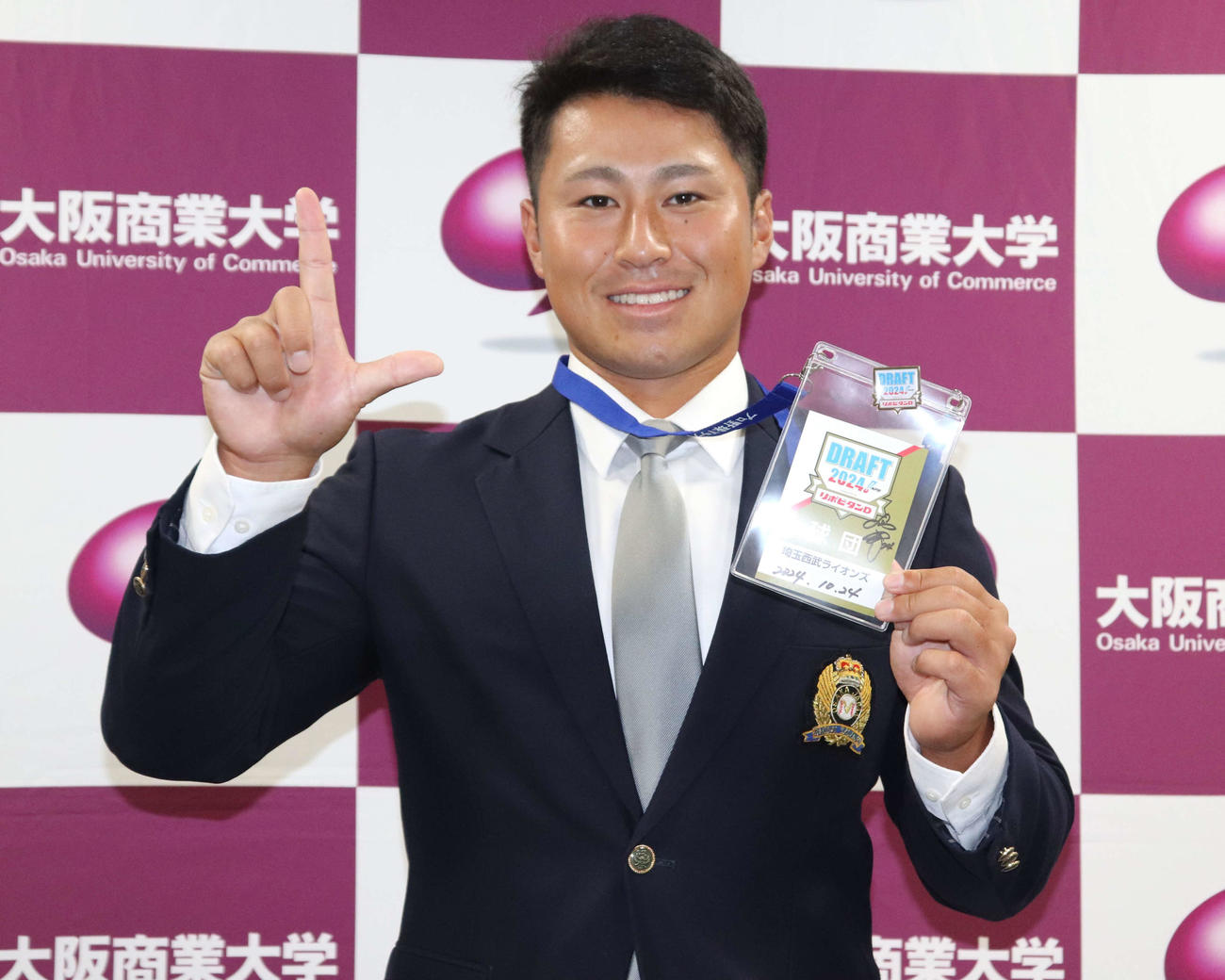 Lポーズで写真に収まる、西武2位大商大・渡部（撮影・中島麗）
