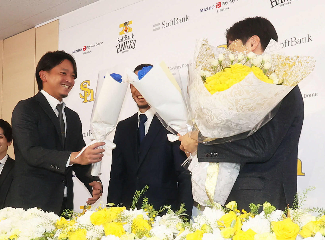 5日、和田（右）の引退会見で東浜（左）は花束を渡す