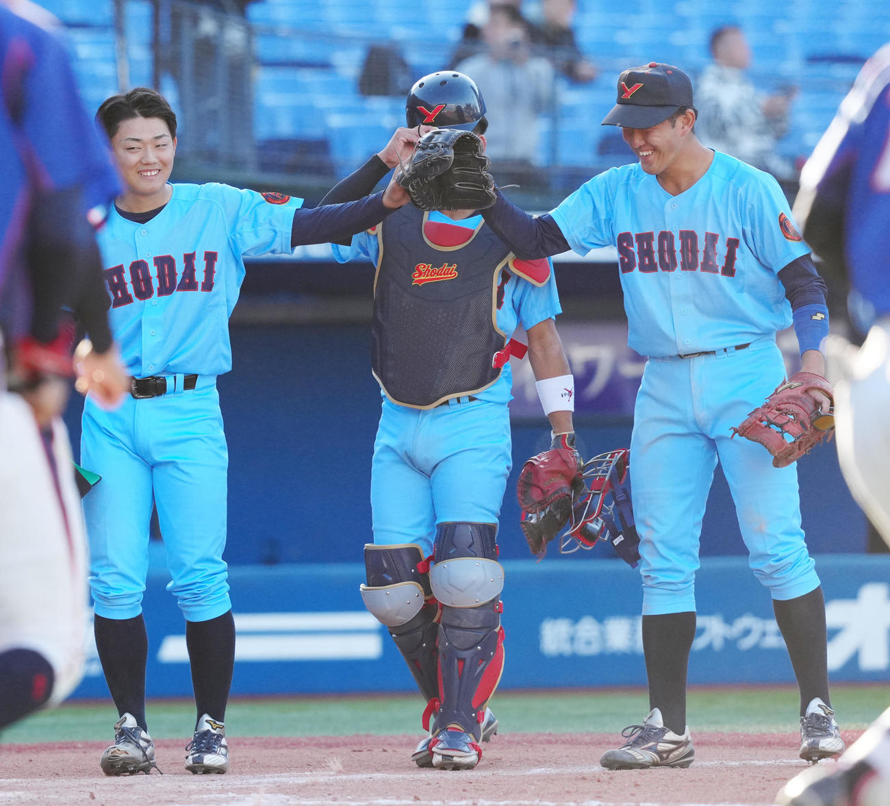 神奈川大対横浜商大　完投勝利を挙げ、横浜商大・奥谷（右）とタッチを交わす駒井（撮影・江口和貴）
