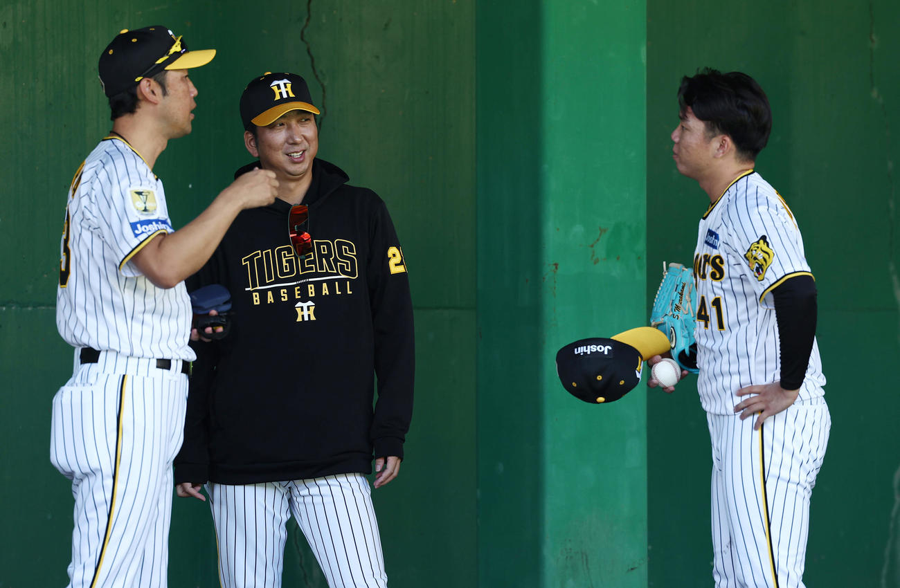 ブルペンで投球練習を終えた阪神村上（右）に声をかける藤川監督。左は金村投手コーチ（2024年11月3日撮影）